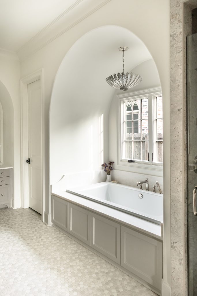 A sweeping arched window in this primary bath